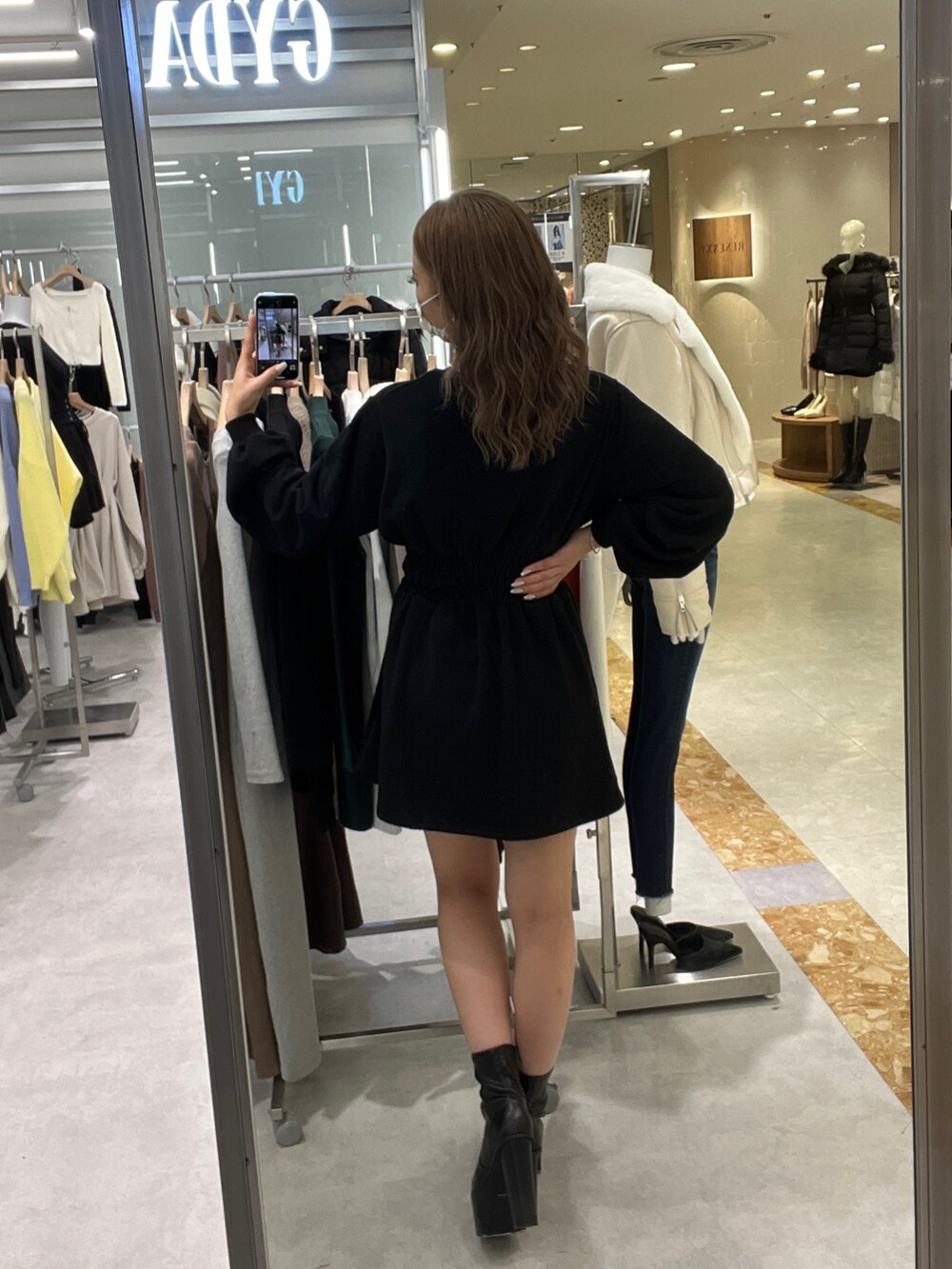 ブラック系のワンピース、ブラック系のブーツを着用したレディースの秋コーディネートの2枚目の写真