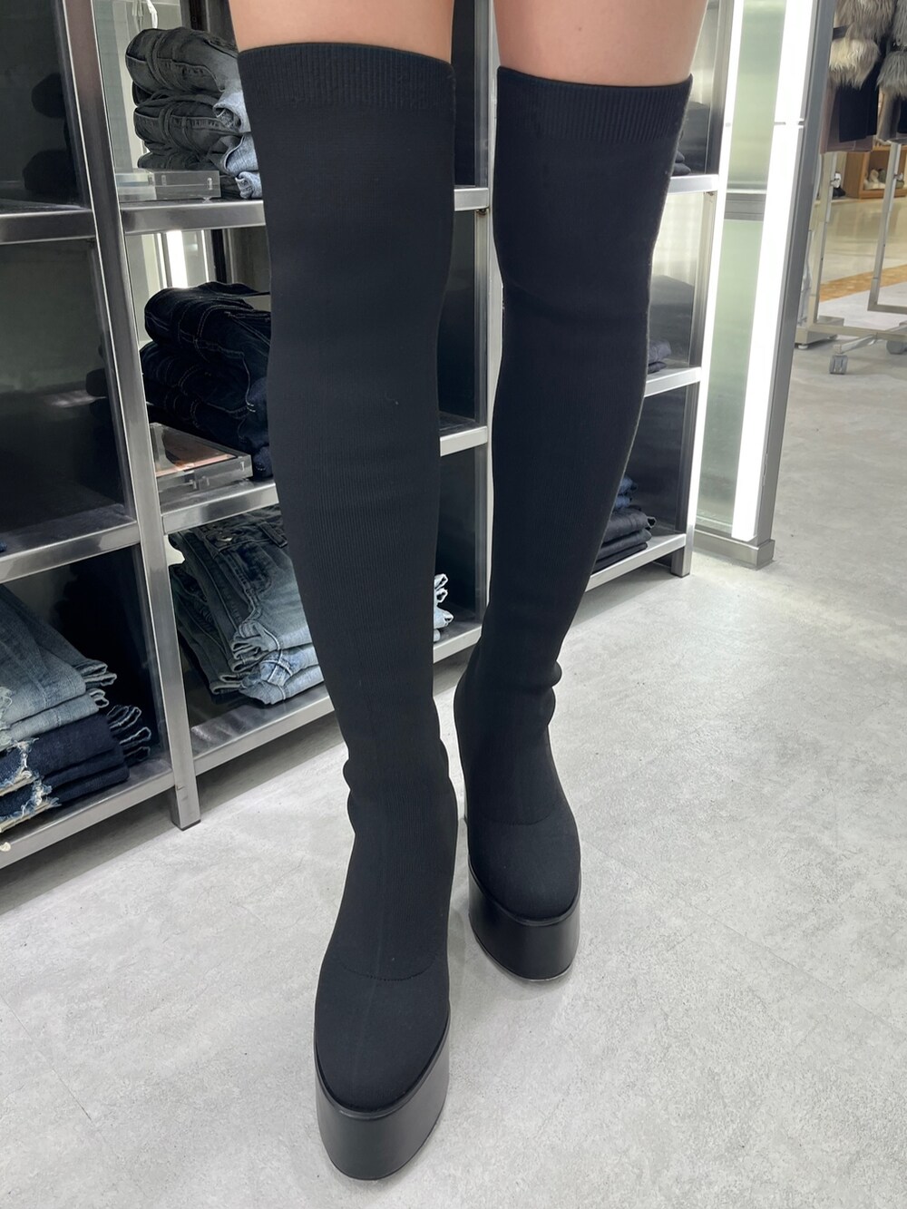 ブラック系のブーツ、ブラック系のその他パンツ、ホワイト系のニット/セーターを着用したレディースの秋コーディネートの5枚目の写真