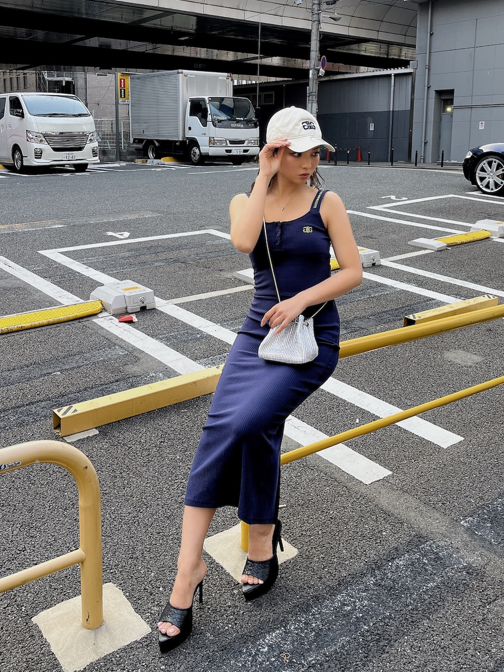 ブルー系のワンピース、ブラック系のパンプスを着用したレディースの春コーディネートの2枚目の写真