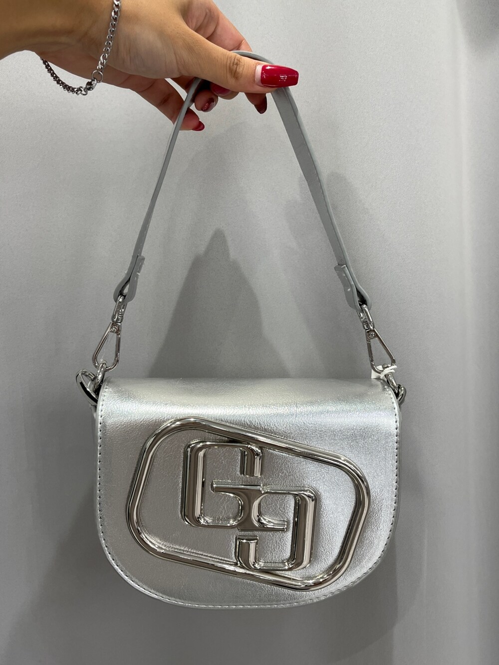 ブルー系のパーカー、シルバー系のハンドバッグ、ブラック系のブーツを着用したレディースの秋コーディネートの6枚目の写真