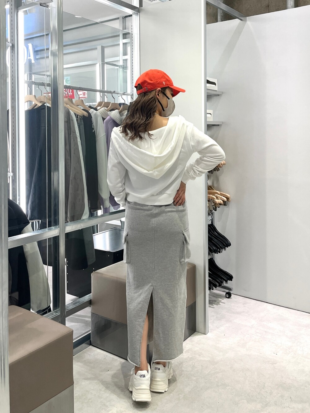 ホワイト系のパーカー、ブラック系のキャミソール、グレー系のスカートを着用したレディースの冬コーディネートの2枚目の写真