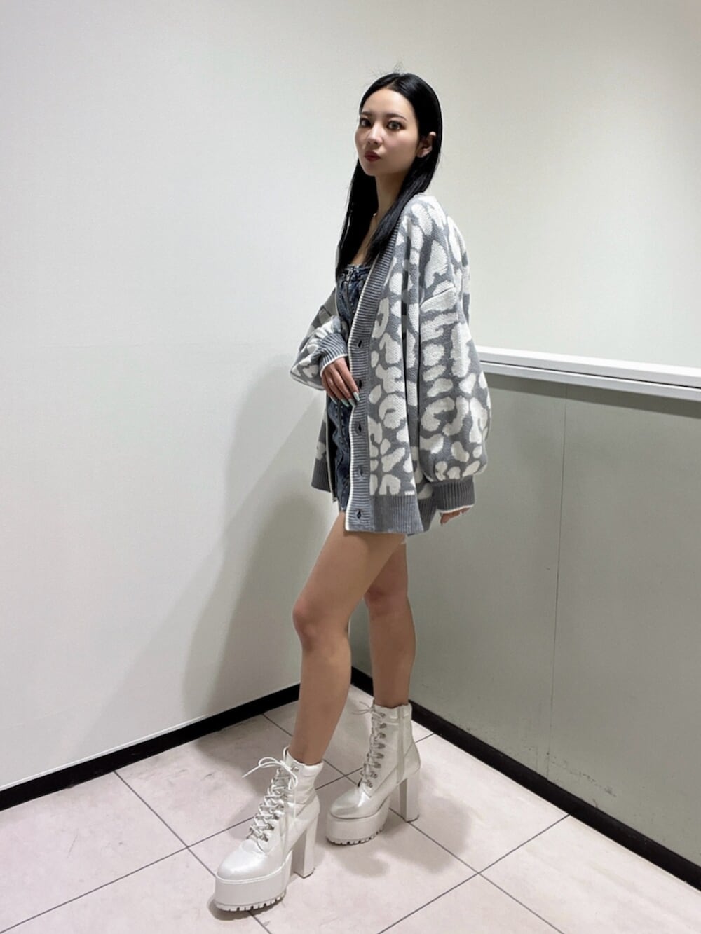 ブルー系のワンピース、ホワイト系のブーツ、グレー系のカーディガン/ボレロを着用したレディースの春コーディネートの3枚目の写真