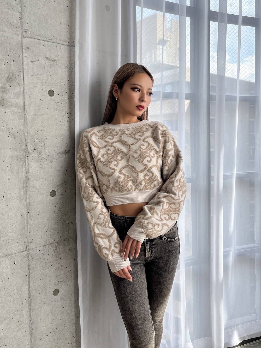 ホワイト系のニット/セーター、ブラック系のデニムパンツ、ホワイト系のブーツを着用したレディースの秋コーディネートの4枚目の写真