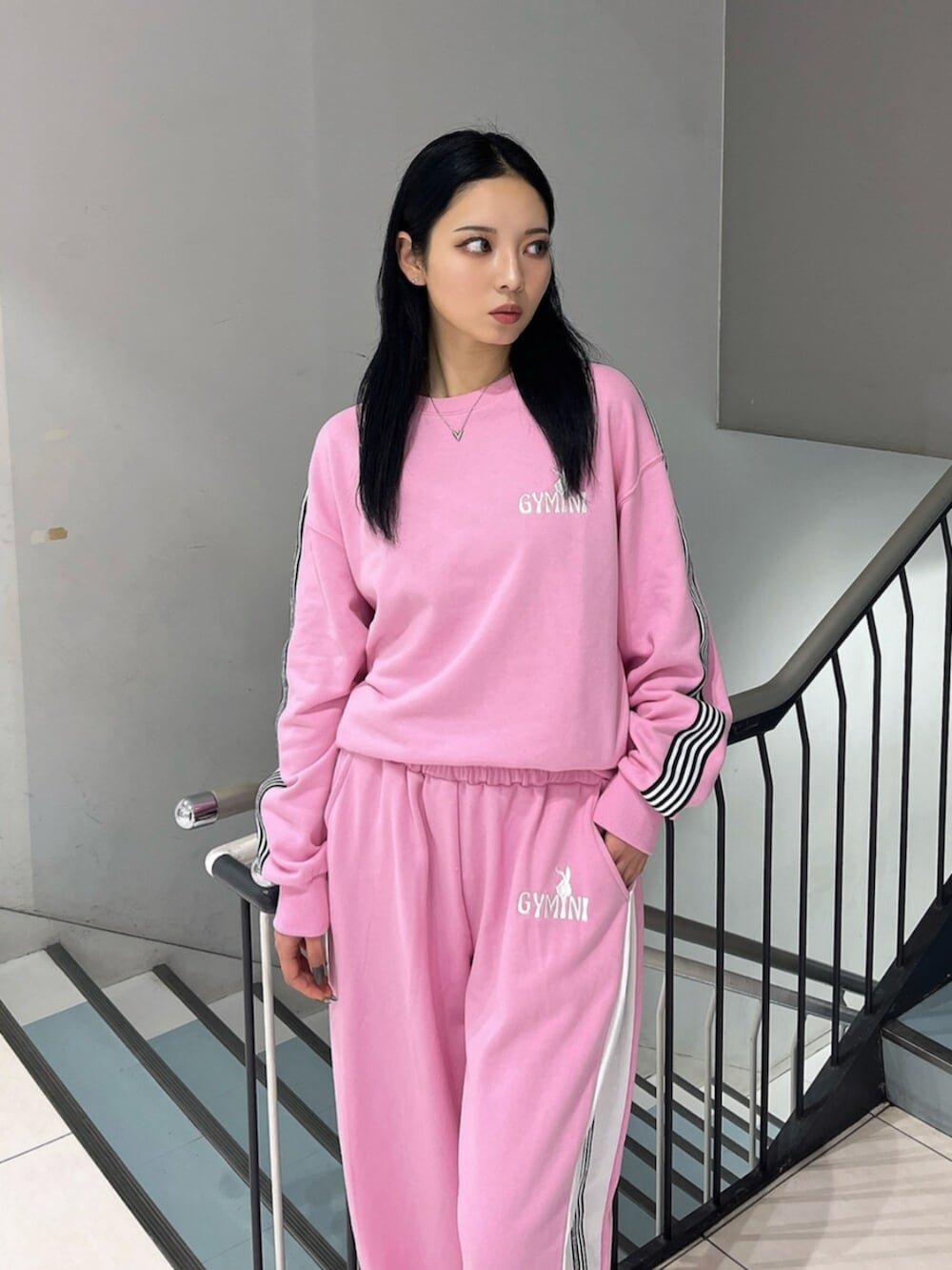 ブラック系のブーツ、ピンク系のスウェット、ピンク系のスウェットパンツを着用したレディースの冬コーディネートの6枚目の写真