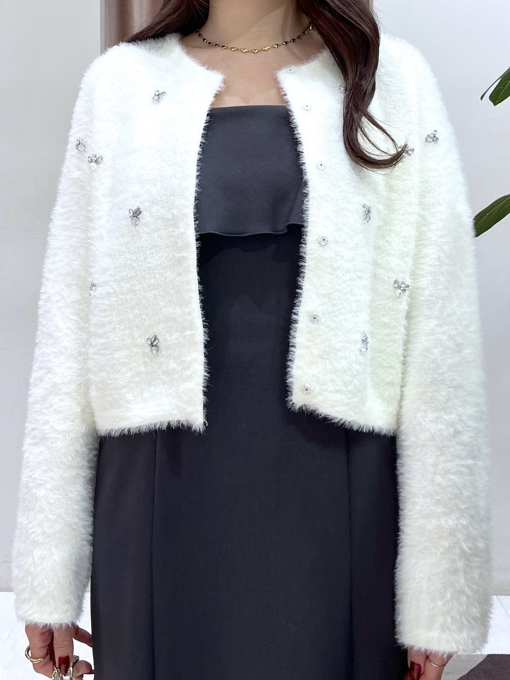 ホワイト系のカーディガン/ボレロ、グレー系のワンピース、シルバー系のハンドバッグを着用したレディースの冬コーディネートの7枚目の写真