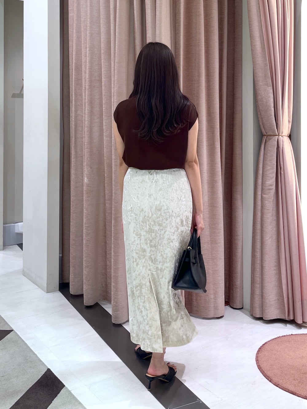 ブラウン系のニット/セーター、ベージュ系のスカート、ブラック系のトートバッグを着用したレディースの夏コーディネートの5枚目の写真