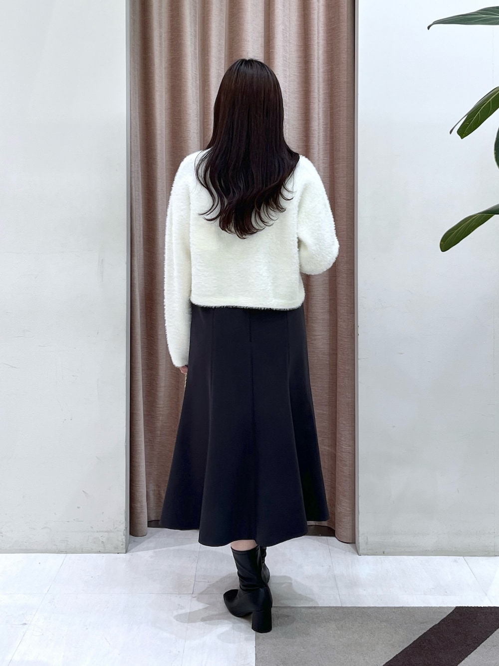 ホワイト系のカーディガン/ボレロ、グレー系のワンピース、シルバー系のハンドバッグを着用したレディースの冬コーディネートの6枚目の写真