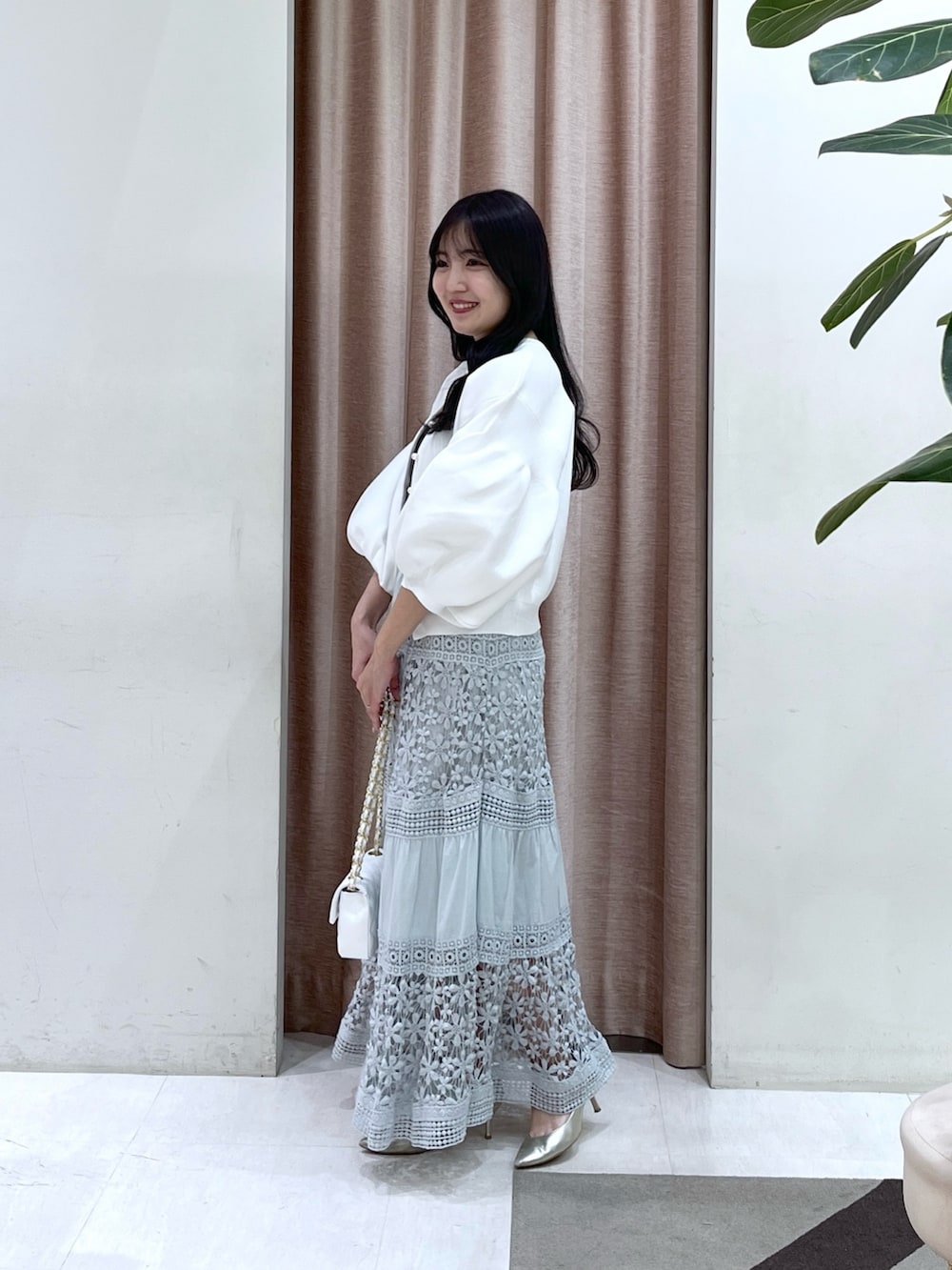 ホワイト系のカーディガン/ボレロ、ブルー系のスカートを着用したレディースの冬コーディネートの4枚目の写真