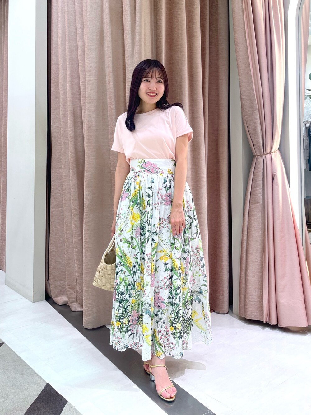 ホワイト系のスカート、ピンク系のTシャツ/カットソー、ベージュ系のトートバッグを着用したレディースの夏コーディネートの3枚目の写真
