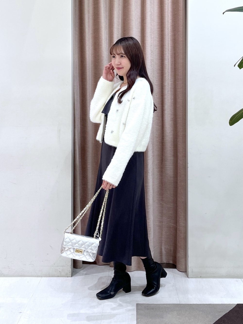 ホワイト系のカーディガン/ボレロ、グレー系のワンピース、シルバー系のハンドバッグを着用したレディースの冬コーディネートの3枚目の写真