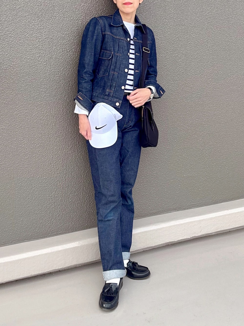 ブルー系のTシャツ/カットソー、ブルー系のデニムパンツ、ブラック系のショルダーバッグを着用したレディースの春コーディネートの2枚目の写真