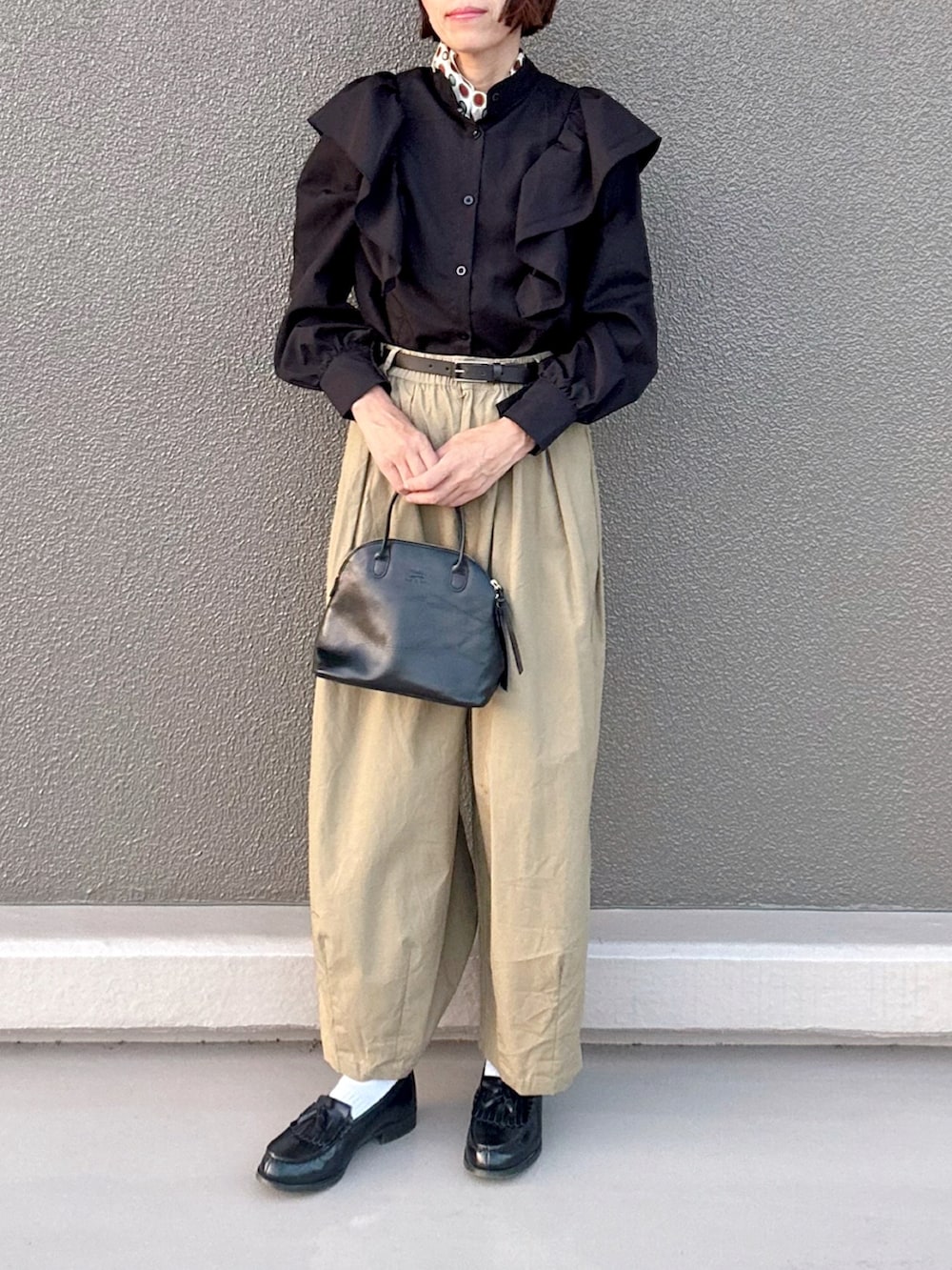 ベージュ系のチノパンツ、ブラック系のシャツ/ブラウス、ブラック系のボストンバッグを着用したレディースの秋コーディネートの2枚目の写真
