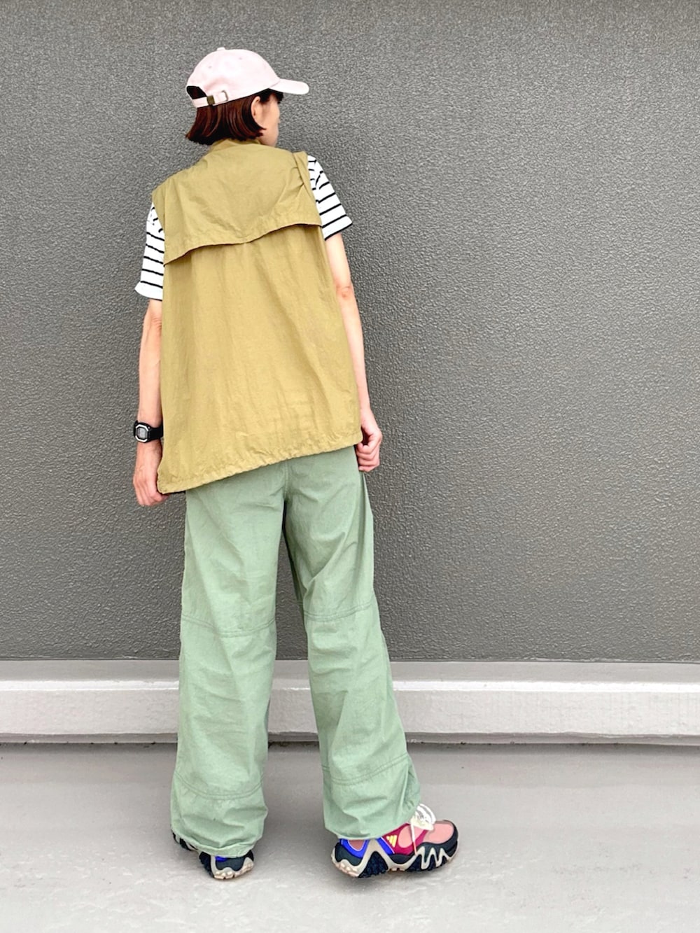 ベージュ系のベスト、グリーン系のその他パンツ、ブラウン系のスニーカーを着用したレディースの夏コーディネートの2枚目の写真