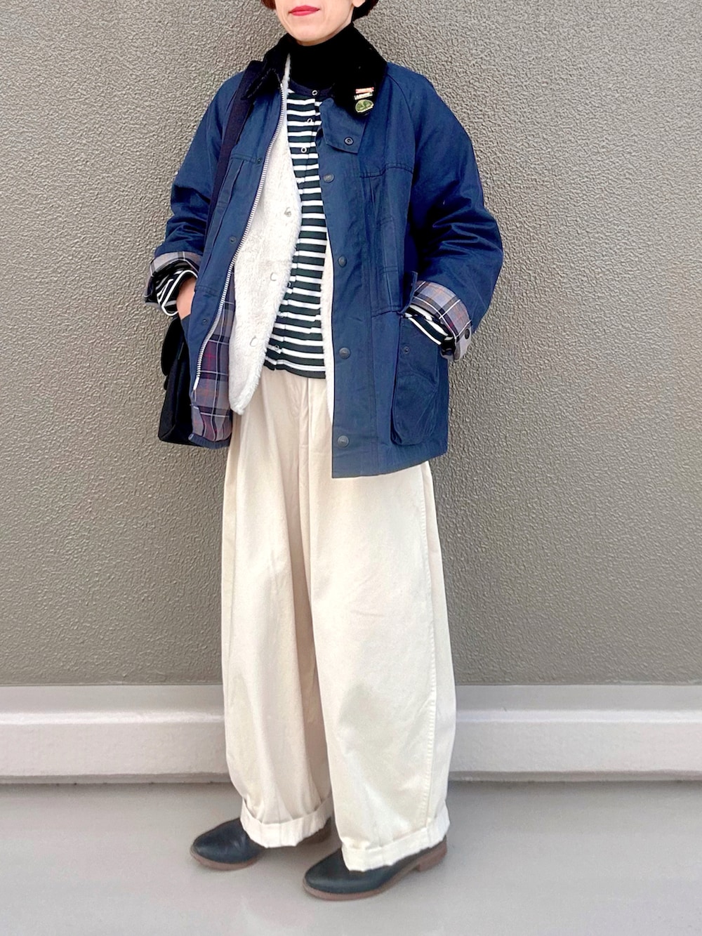 ブラック系のニット/セーター、ブラック系のカーディガン/ボレロ、ブルー系のブルゾンを着用したレディースの冬コーディネートの2枚目の写真