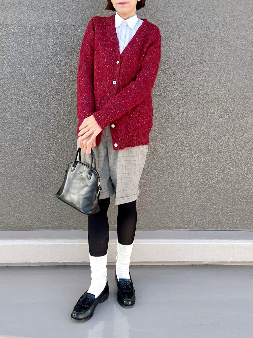 レッド系のカーディガン/ボレロ、ブラウン系のその他パンツ、ブラック系のボストンバッグを着用したレディースの秋コーディネートの2枚目の写真
