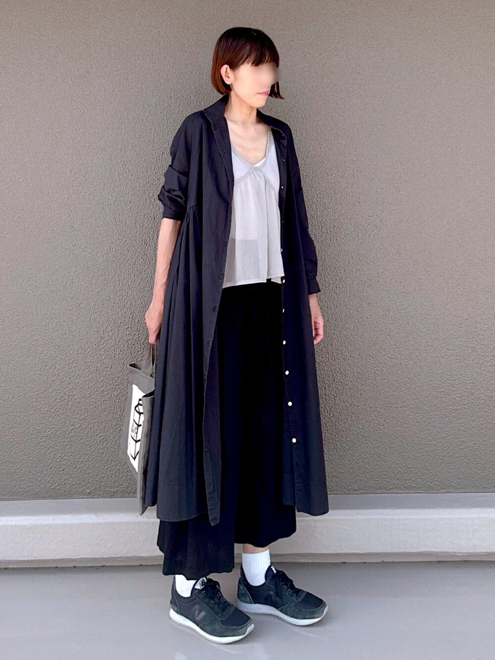 ブラック系のシャツワンピース、ブラック系のスニーカー、グレー系のトートバッグを着用したレディースの夏コーディネートの3枚目の写真