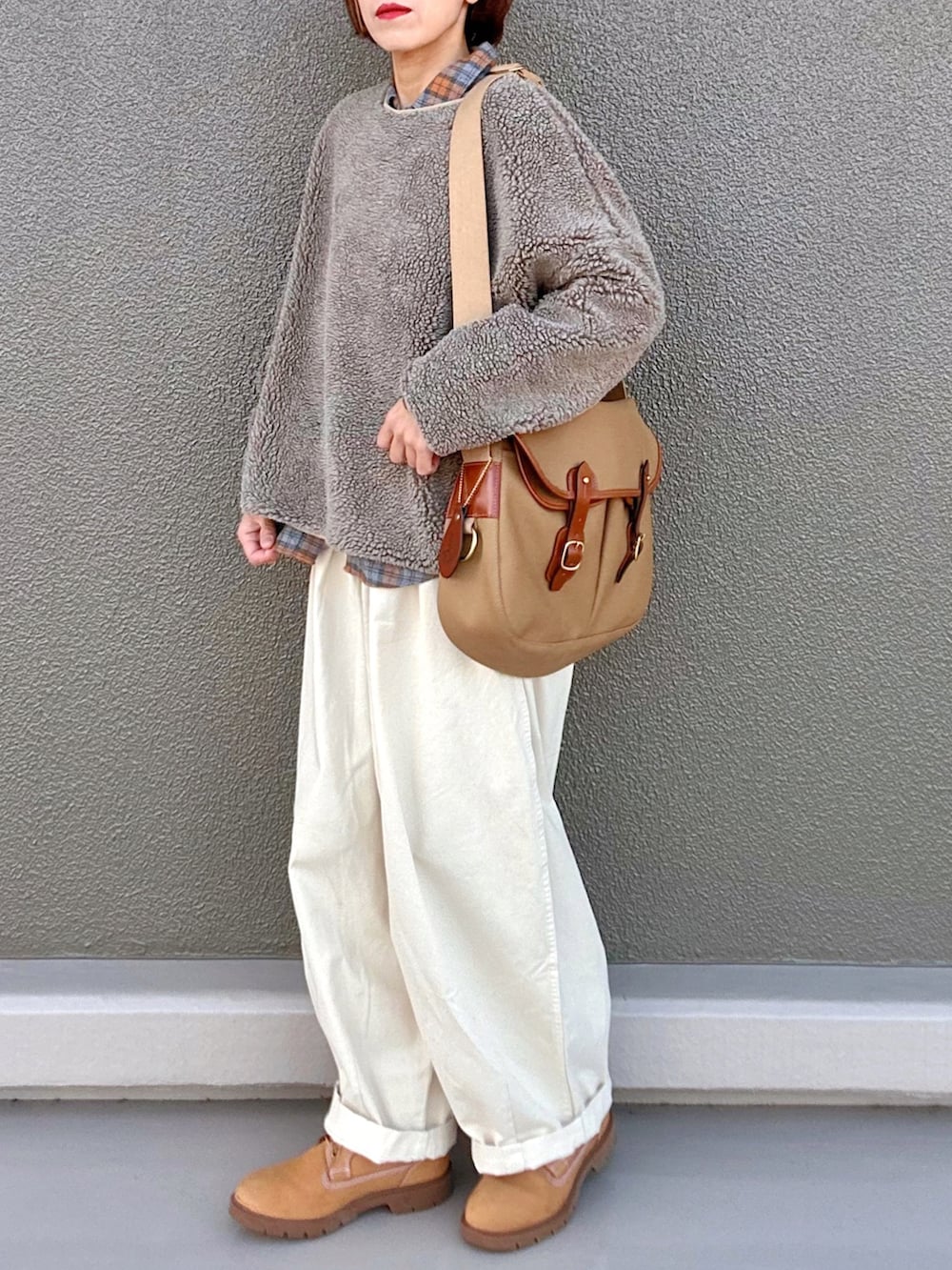 オレンジ系のシャツ/ブラウス、イエロー系のショルダーバッグ、ベージュ系のトップスを着用したレディースの冬コーディネートの3枚目の写真