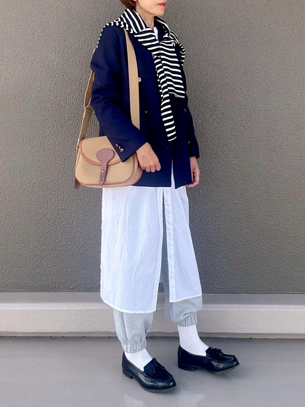 ブルー系のテーラードジャケット、ホワイト系のシャツワンピース、ブラック系のカーディガン/ボレロを着用したレディースの秋コーディネートの3枚目の写真