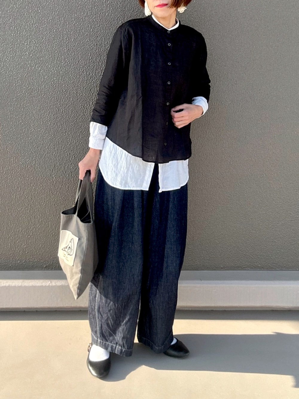 ブラック系のシャツ/ブラウス、ブルー系のデニムパンツ、グレー系のトートバッグを着用したレディースの春コーディネートの3枚目の写真