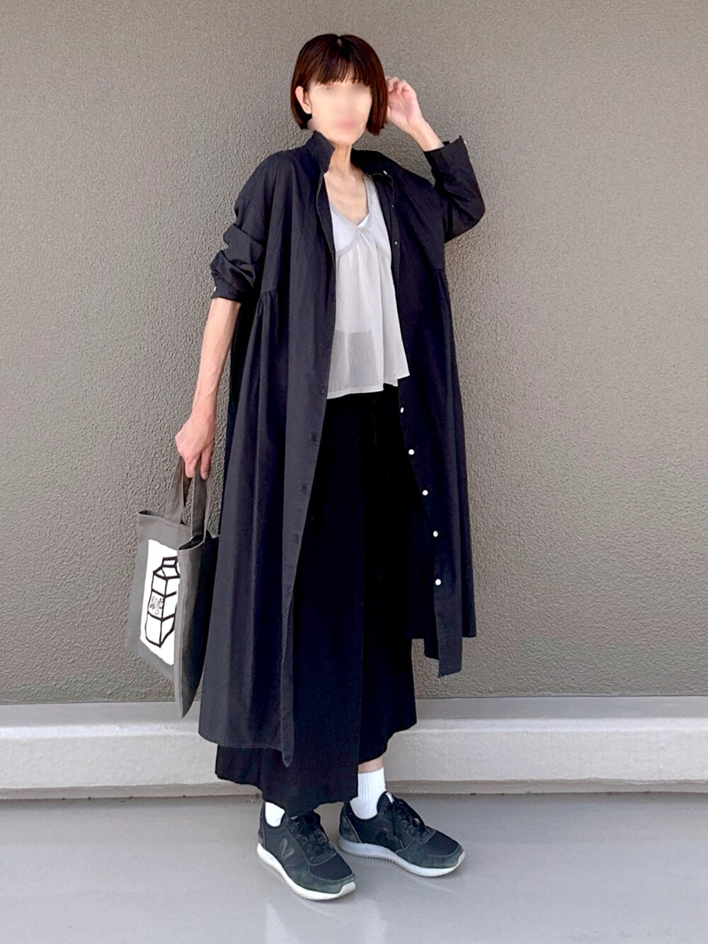 ブラック系のシャツワンピース、ブラック系のスニーカー、グレー系のトートバッグを着用したレディースの夏コーディネートの2枚目の写真