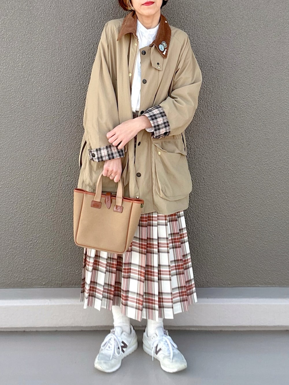 ベージュ系のブルゾン、ホワイト系のスカート、グリーン系のトートバッグを着用したレディースの春コーディネートの3枚目の写真