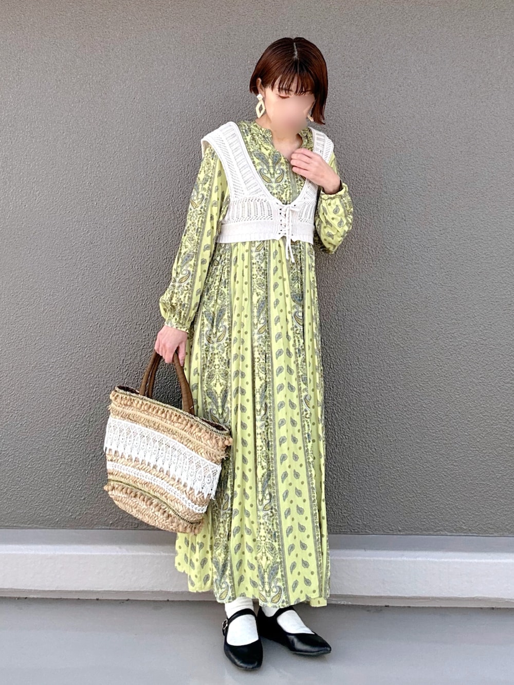 イエロー系のワンピース、ベージュ系のかごバッグ、ブラック系のバレエシューズを着用したレディースの春コーディネートの3枚目の写真