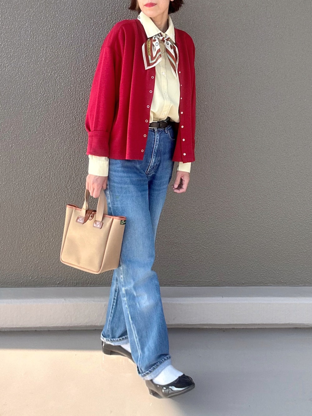 レッド系のカーディガン/ボレロ、ブラック系のバレエシューズ、イエロー系のシャツ/ブラウスを着用したレディースの秋コーディネートの3枚目の写真