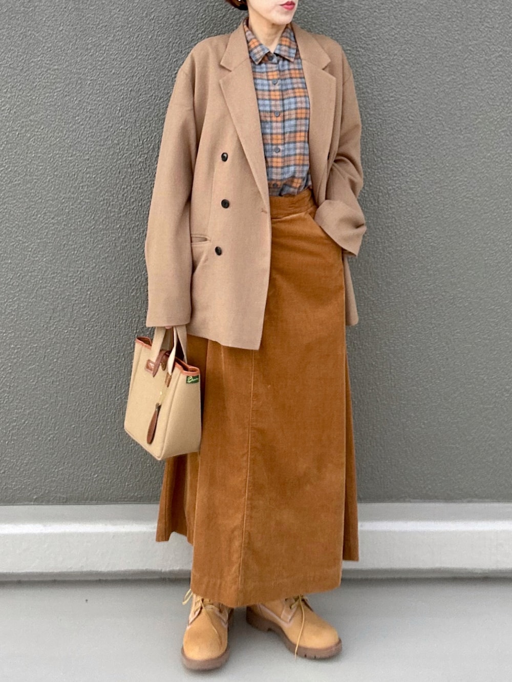 オレンジ系のシャツ/ブラウス、ブラウン系のテーラードジャケット、イエロー系のスカートを着用したレディースの冬コーディネートの3枚目の写真