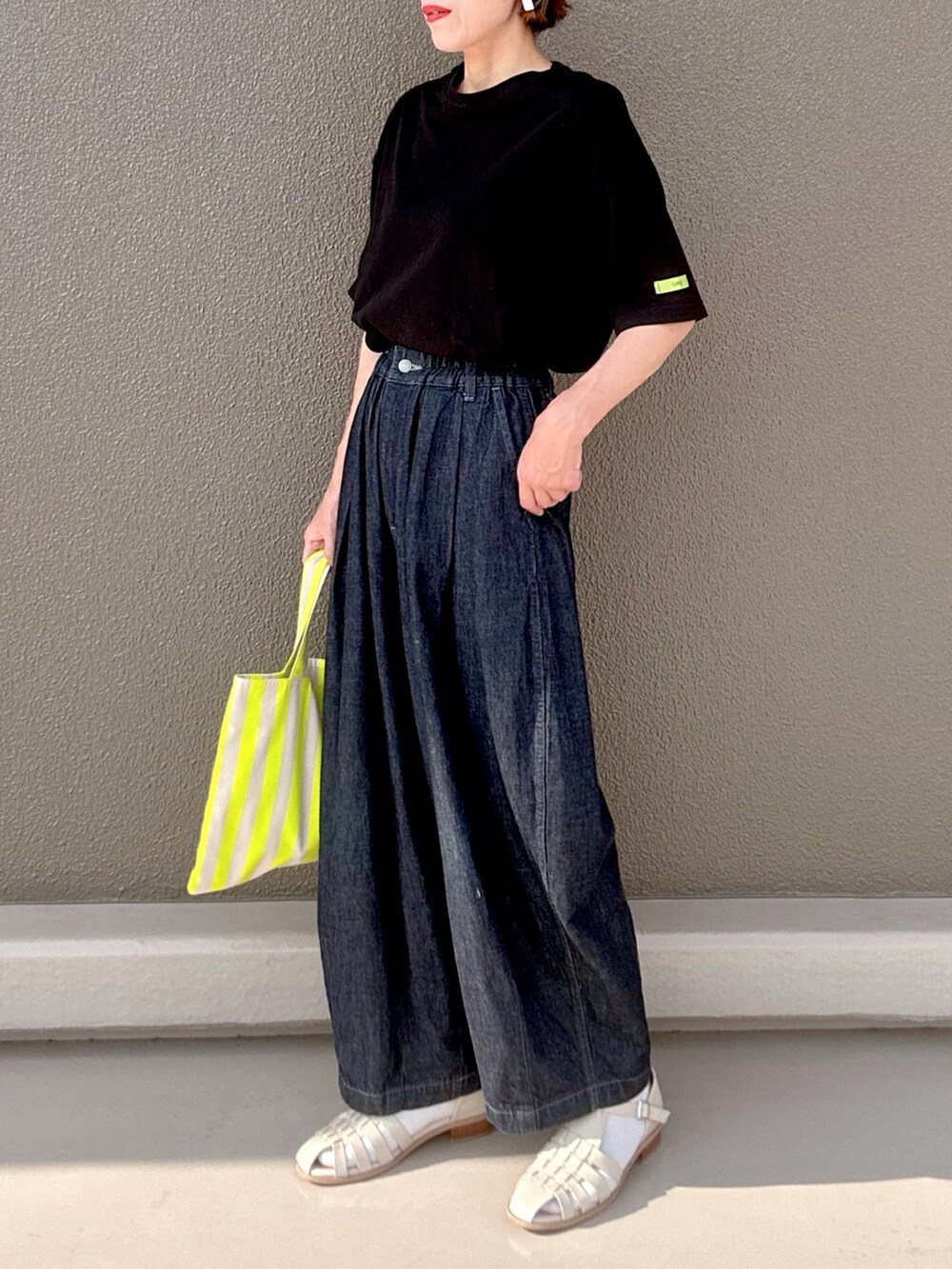 ホワイト系のサンダル、ブルー系のデニムパンツ、ブラック系のTシャツ/カットソーを着用したレディースの夏コーディネートの3枚目の写真