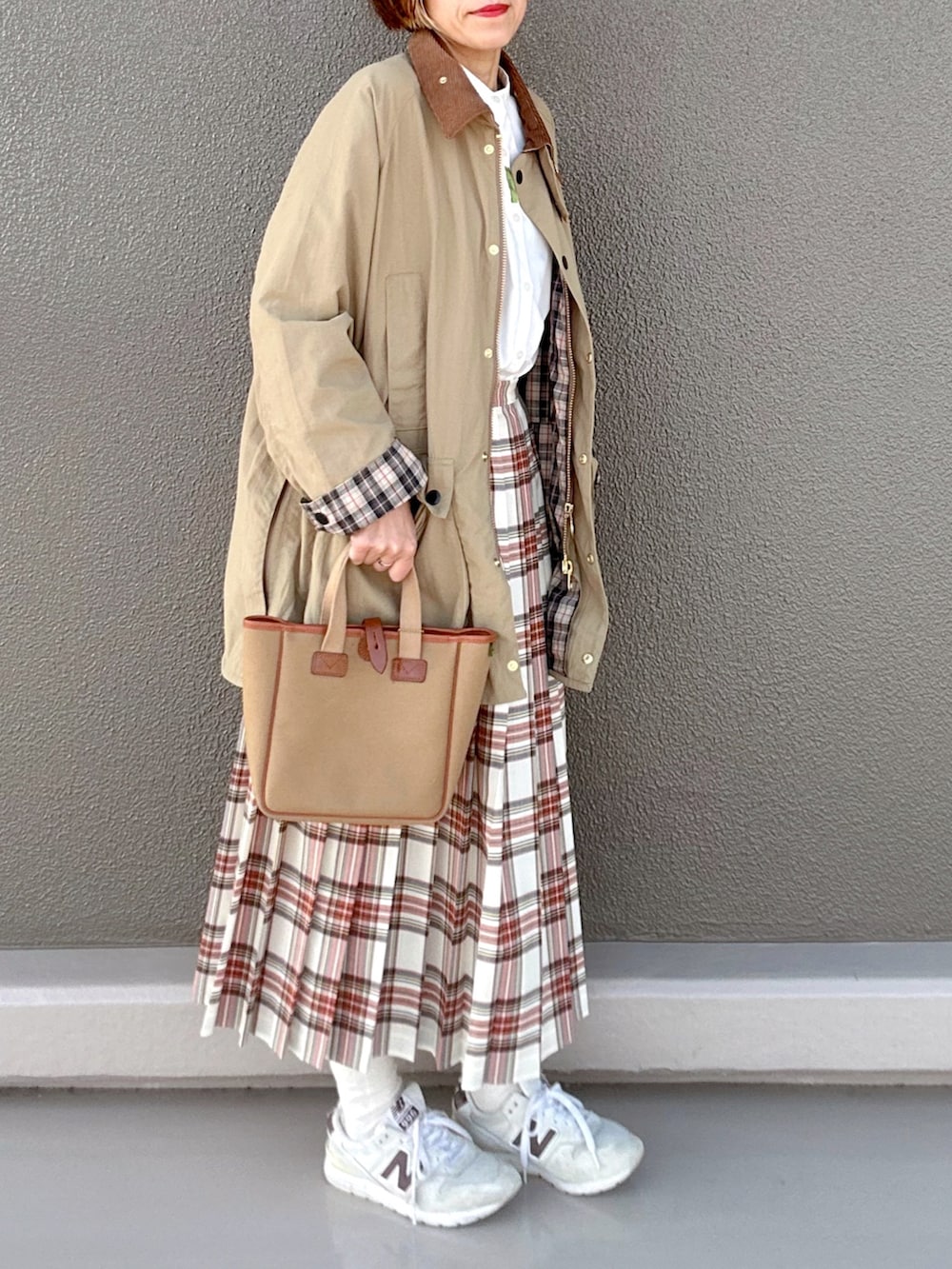ベージュ系のブルゾン、ホワイト系のスカート、グリーン系のトートバッグを着用したレディースの春コーディネートの2枚目の写真