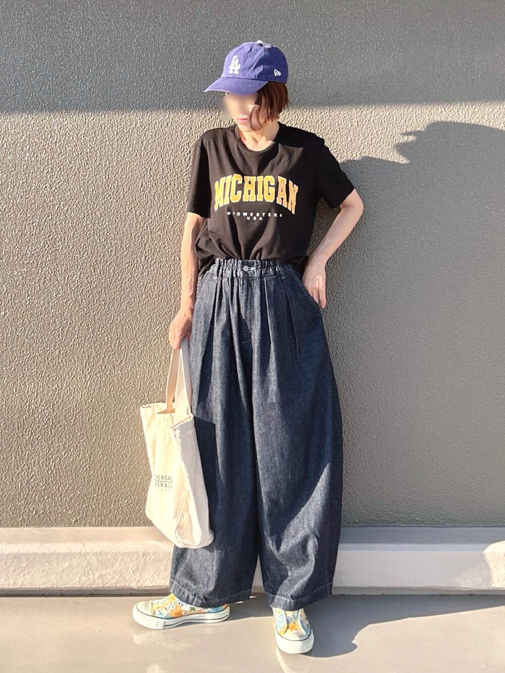 ブラック系のTシャツ/カットソー、ブルー系のデニムパンツ、ホワイト系のトートバッグを着用したレディースの夏コーディネートの2枚目の写真