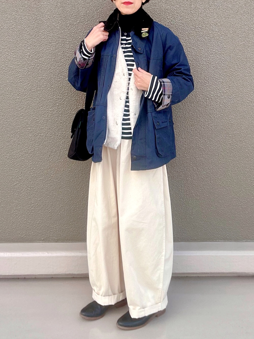 ブラック系のニット/セーター、ブラック系のカーディガン/ボレロ、ブルー系のブルゾンを着用したレディースの冬コーディネートの3枚目の写真