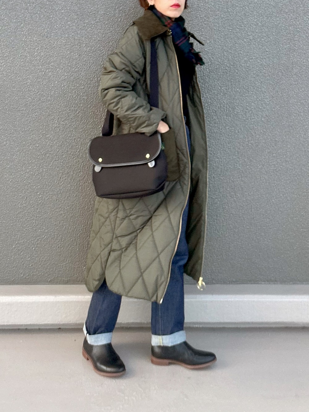 ブラック系のブーツ、ブラック系のニット/セーター、グリーン系のその他アウターを着用したレディースの冬コーディネートの3枚目の写真