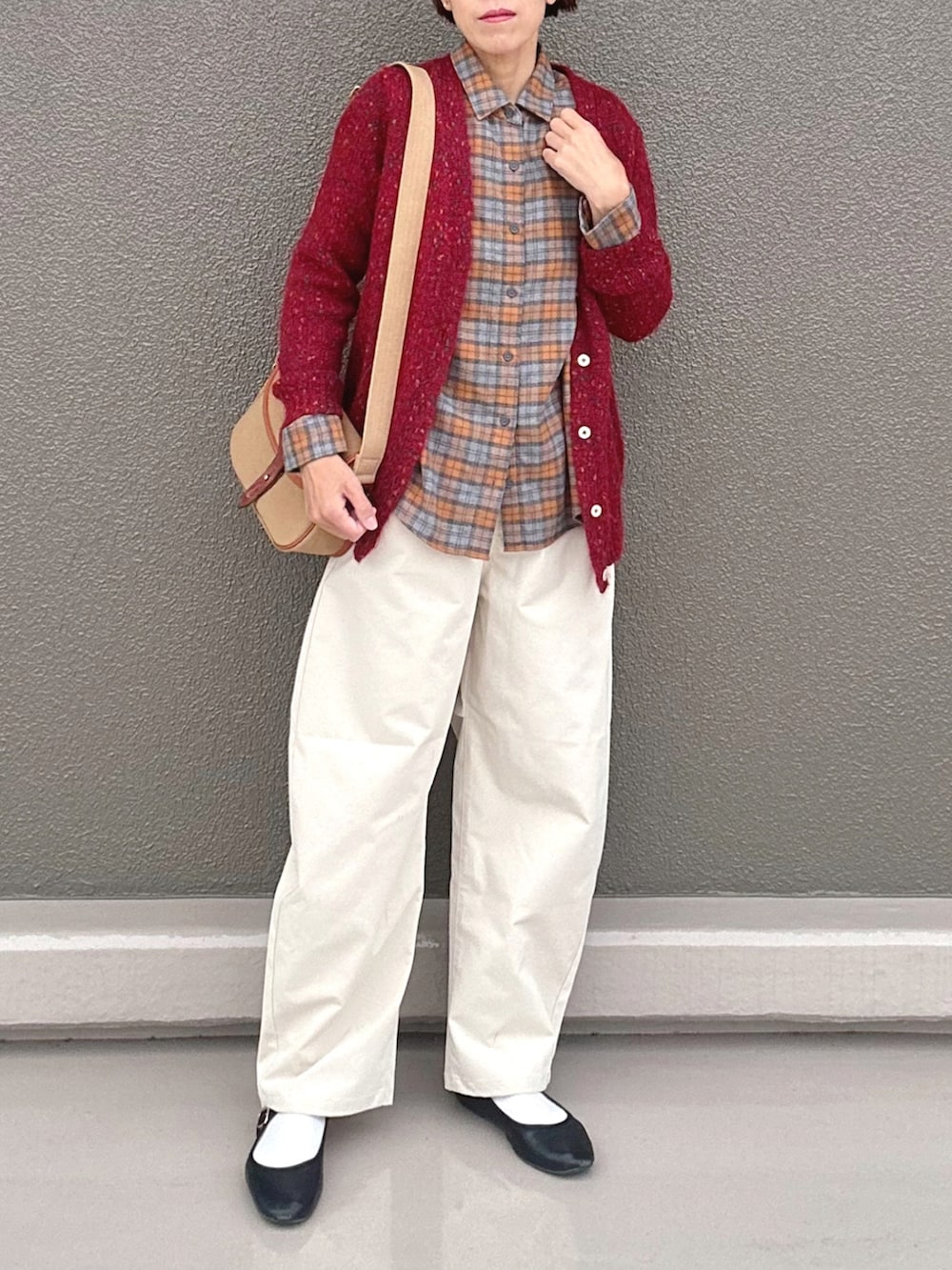 オレンジ系のシャツ/ブラウス、レッド系のカーディガン/ボレロ、ホワイト系のチノパンツを着用したレディースの秋コーディネートの2枚目の写真
