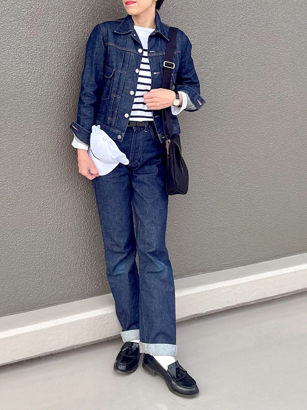 ブルー系のTシャツ/カットソー、ブルー系のデニムパンツ、ブラック系のショルダーバッグを着用したレディースの春コーディネートの3枚目の写真