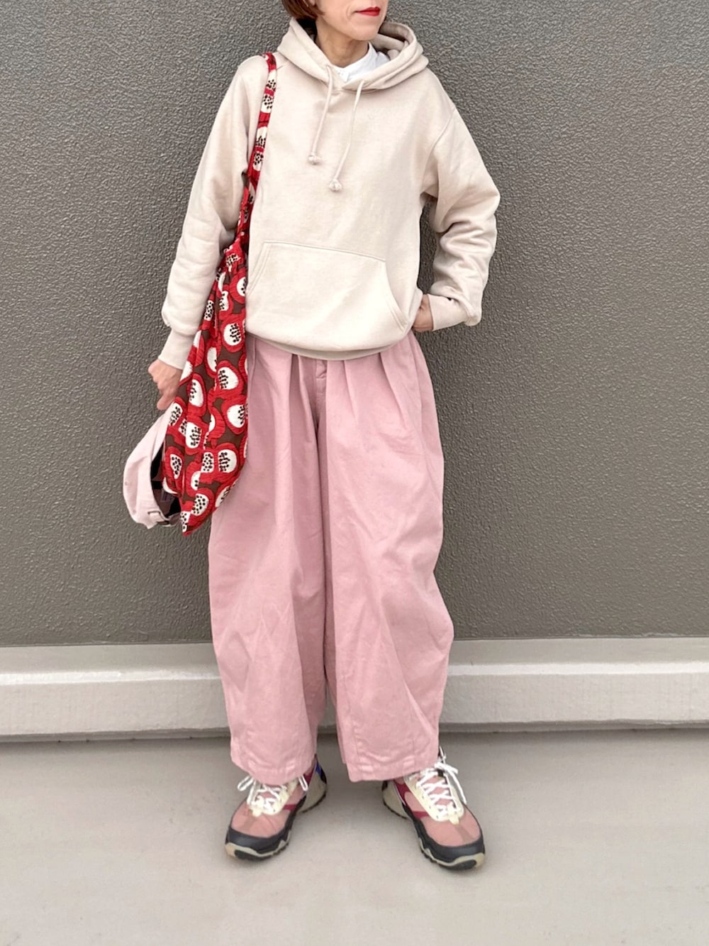 ピンク系のパンツ、ホワイト系のパーカー、ブラウン系のスニーカーを着用したレディースの春コーディネートの2枚目の写真