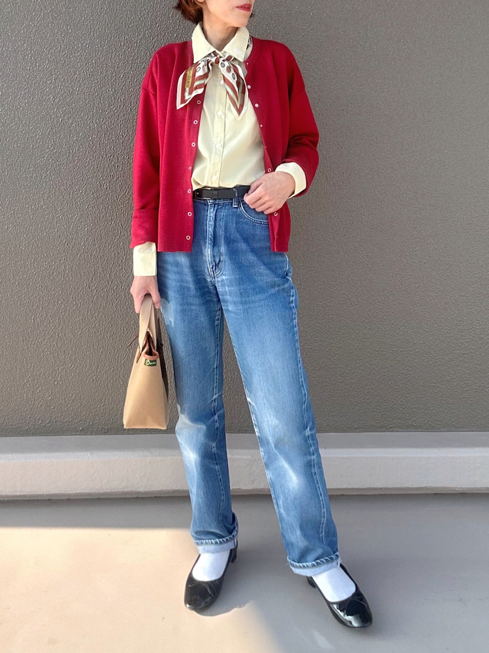 レッド系のカーディガン/ボレロ、ブラック系のバレエシューズ、イエロー系のシャツ/ブラウスを着用したレディースの秋コーディネートの2枚目の写真