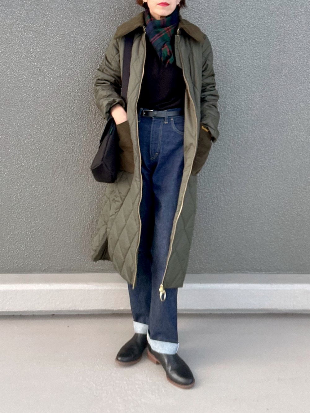 ブラック系のブーツ、ブラック系のニット/セーター、グリーン系のその他アウターを着用したレディースの冬コーディネートの2枚目の写真