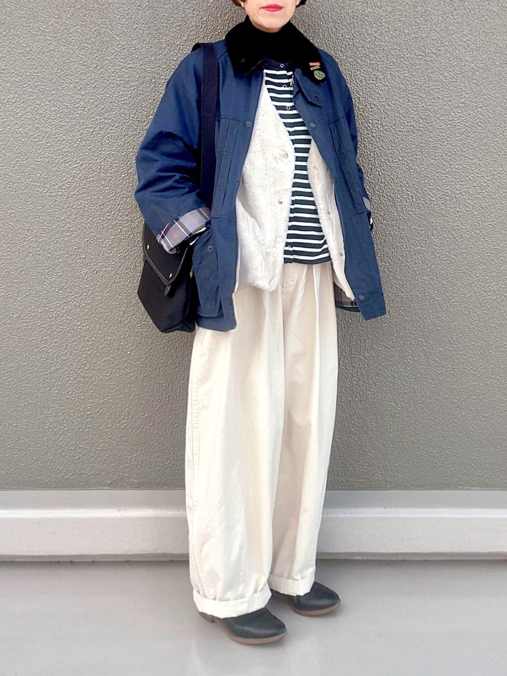 ブラック系のニット/セーター、ブラック系のカーディガン/ボレロ、ブルー系のブルゾンを着用したレディースの冬コーディネートの4枚目の写真