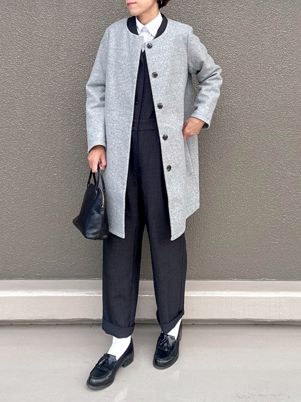 グレー系のジャケット/アウター、ブラック系のサロペット/オーバーオール、ブラック系のボストンバッグを着用したレディースの冬コーディネートの2枚目の写真