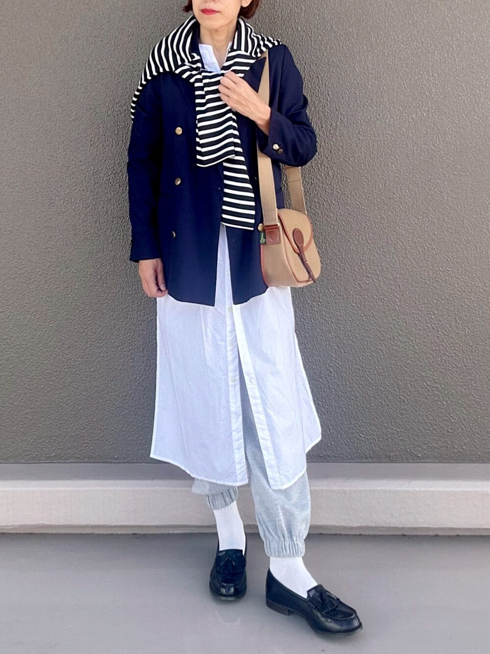 ブルー系のテーラードジャケット、ホワイト系のシャツワンピース、ブラック系のカーディガン/ボレロを着用したレディースの秋コーディネートの2枚目の写真