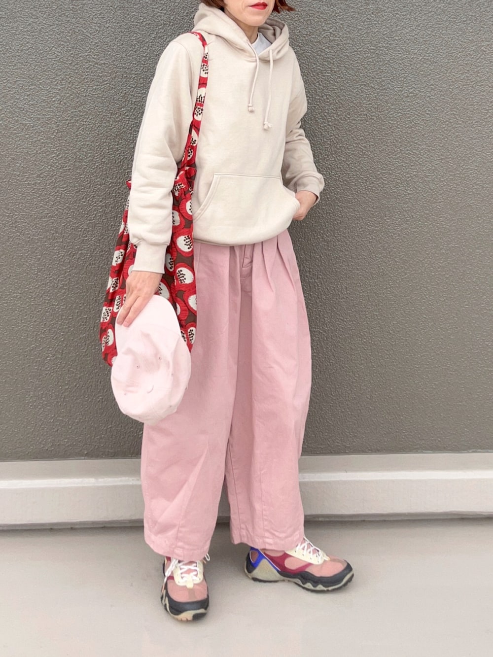 ピンク系のパンツ、ホワイト系のパーカー、ブラウン系のスニーカーを着用したレディースの春コーディネートの3枚目の写真