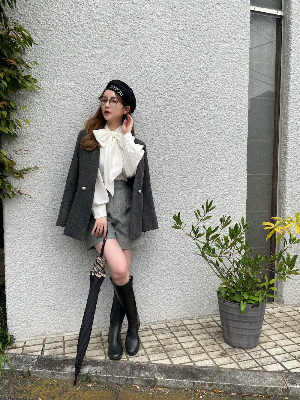 グレー系のノーカラーコート、グレー系のパンツ、ブラック系のハンチング/ベレー帽を着用したレディースの秋コーディネートの4枚目の写真