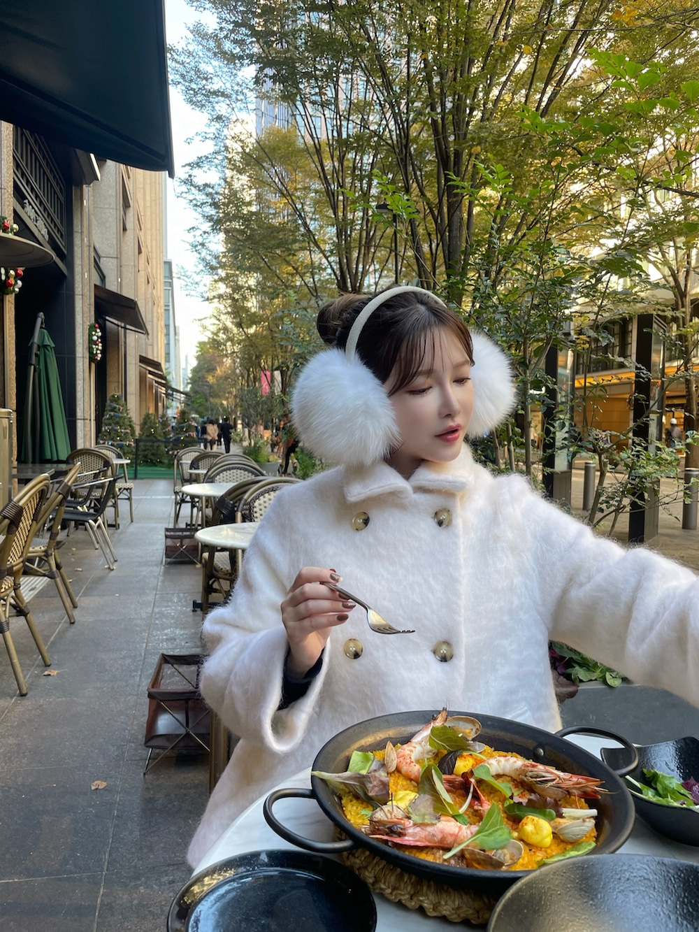 ホワイト系のチェスターコートを着用したレディースの冬コーディネートの2枚目の写真