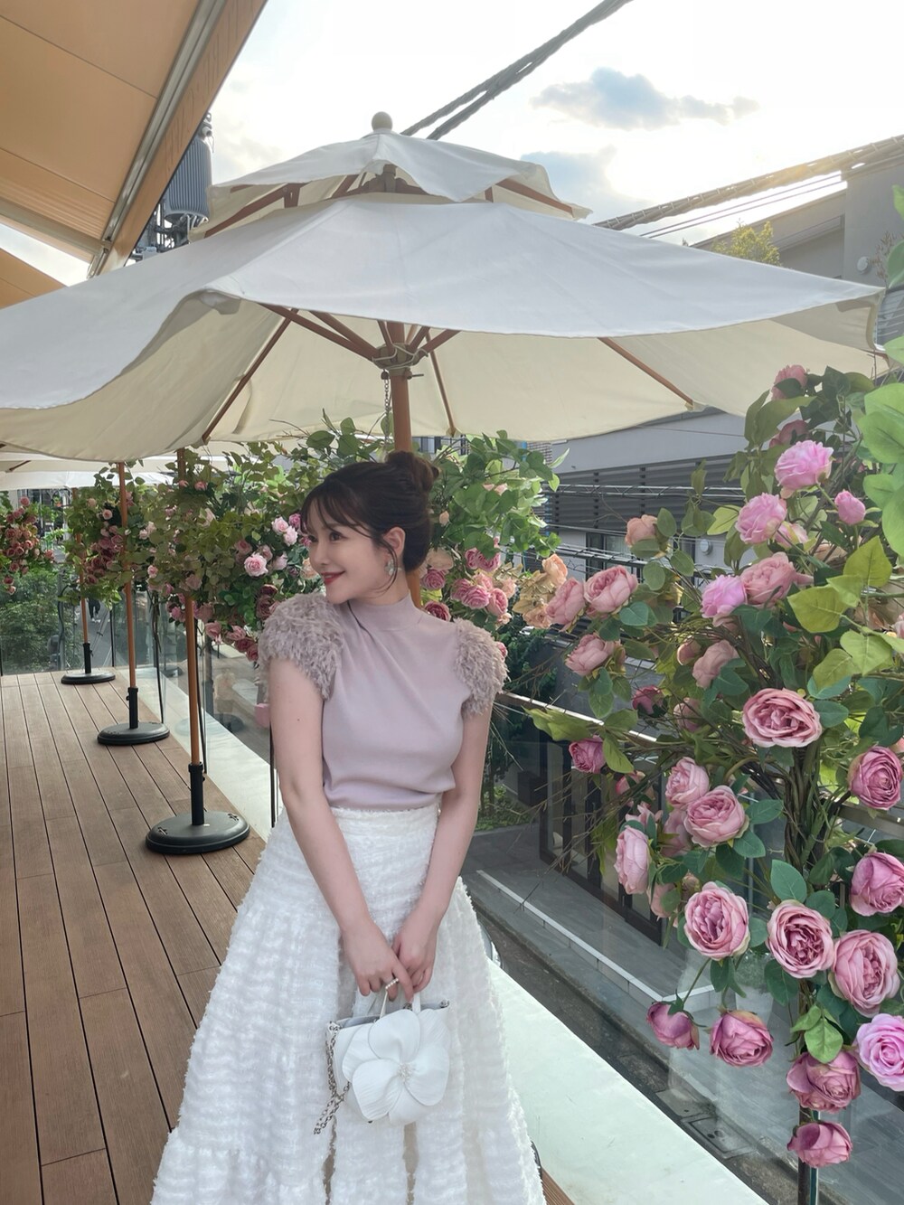 ピンク系のニット/セーター、ホワイト系のスカートを着用したレディースの秋コーディネートの2枚目の写真