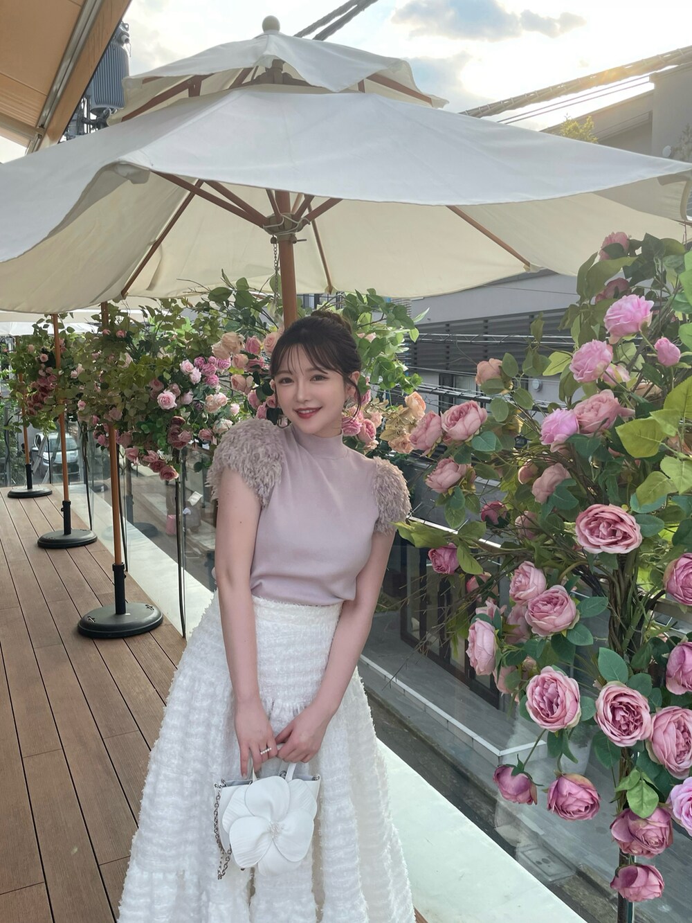 ピンク系のニット/セーター、ホワイト系のスカートを着用したレディースの秋コーディネートの3枚目の写真