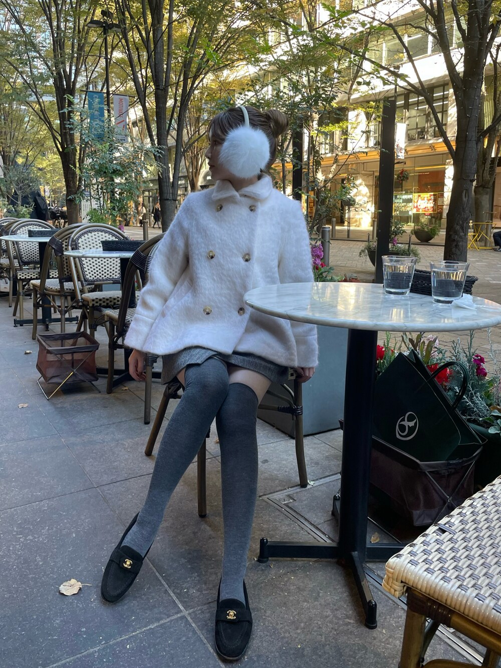 ホワイト系のチェスターコートを着用したレディースの冬コーディネートの3枚目の写真