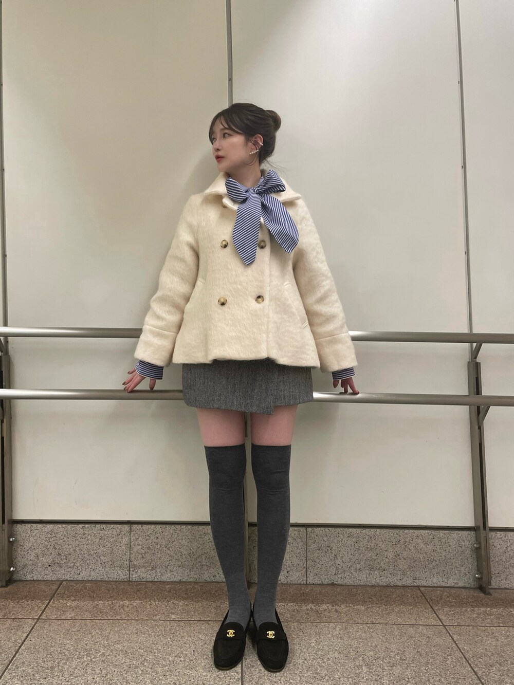 ホワイト系のチェスターコートを着用したレディースの冬コーディネートの5枚目の写真