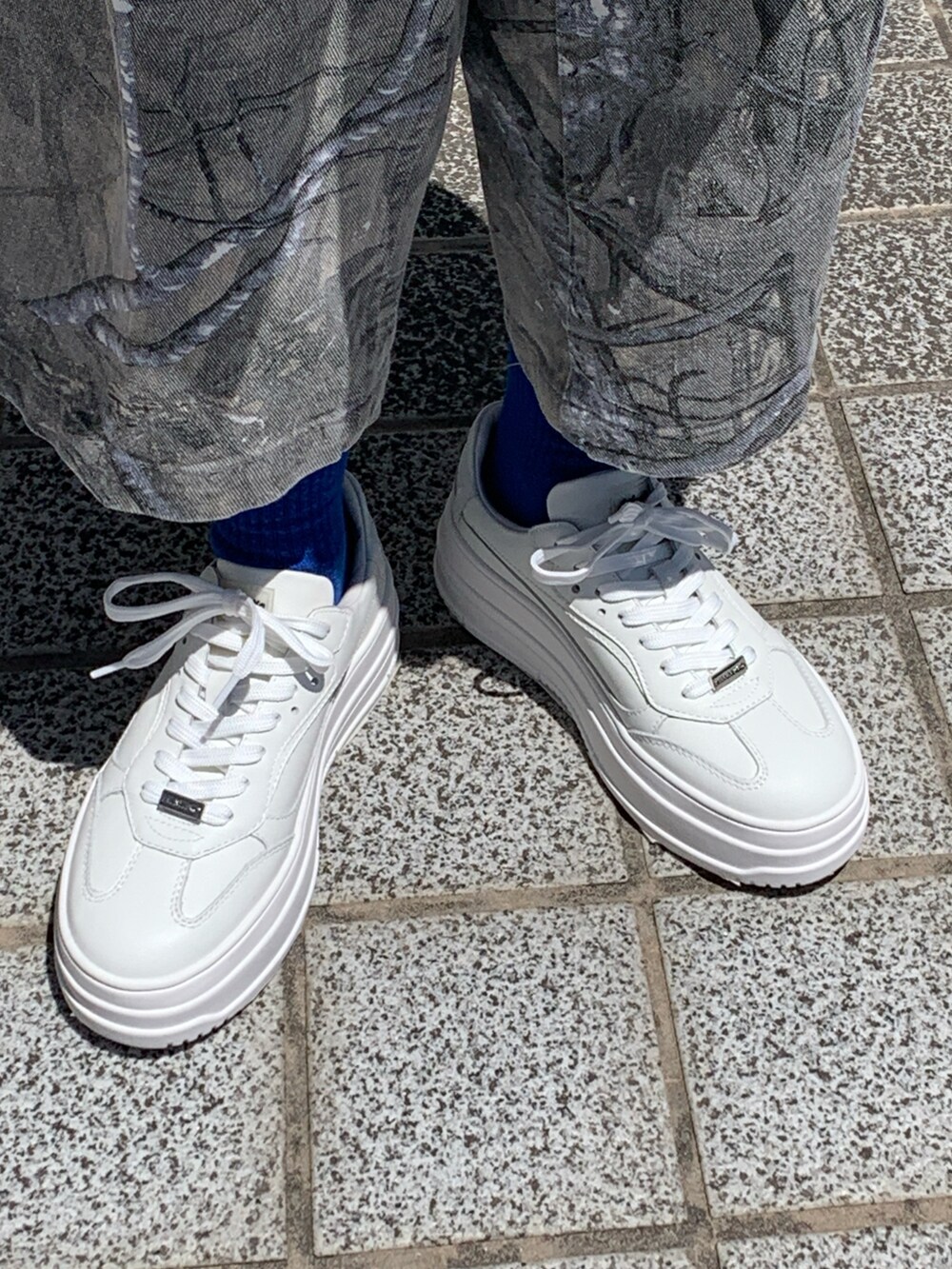 ホワイト系のスニーカーを着用したレディースの春コーディネートの2枚目の写真