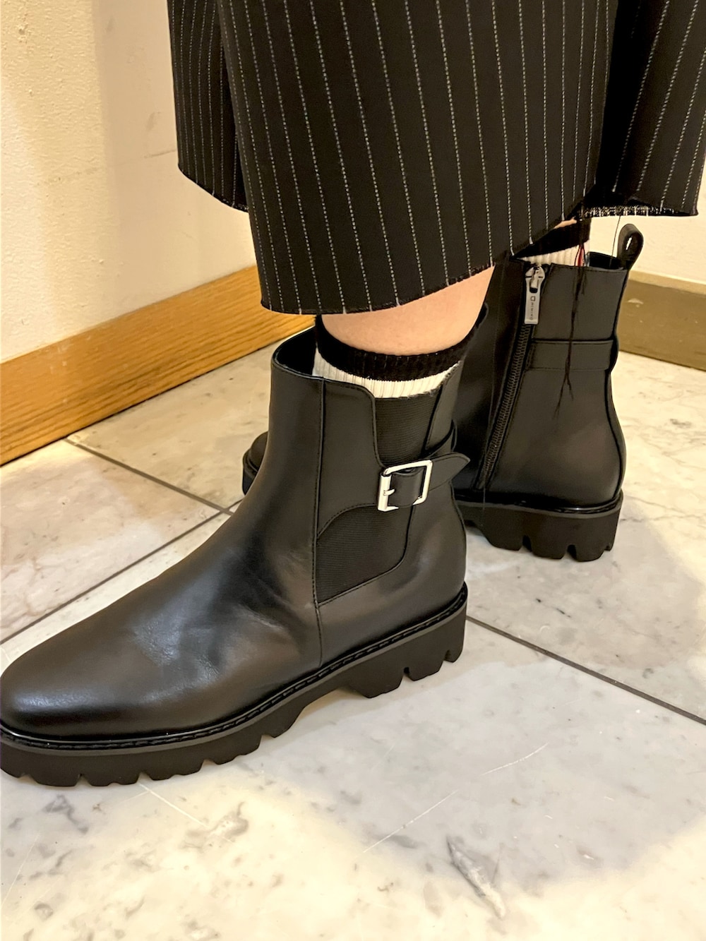 ブラック系のブーツを着用したレディースの秋コーディネートの2枚目の写真